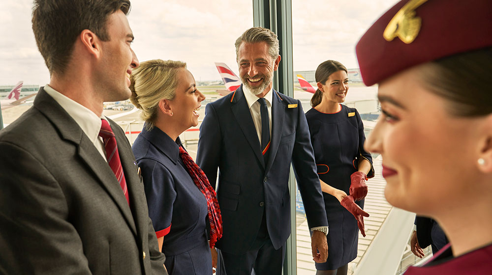 Una piscina con las tumbonas de Iberia, British Airways y Qatar Airways con el fondo de la playa.