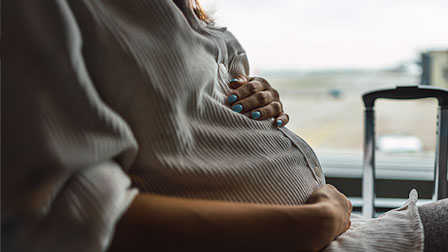 Mujeres embarazadas Mujer embarazada acariciando su barriga por encima de una camisa verde.