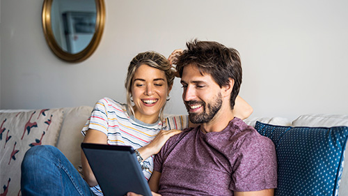 Couple pre-booking flights on a tablet 