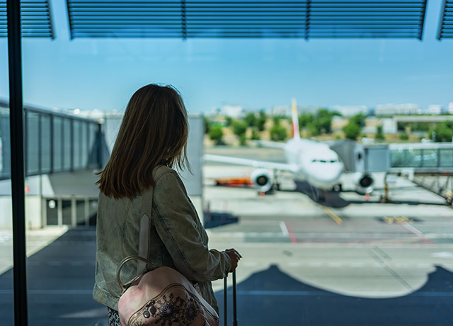  Woman with her carry-on bag waiting to board the Iberia plane