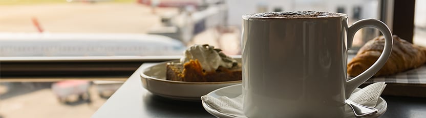 Aeropuerto La imagen muestra el detalle de una persona comiendo una ensalada junto a un acompañante.
