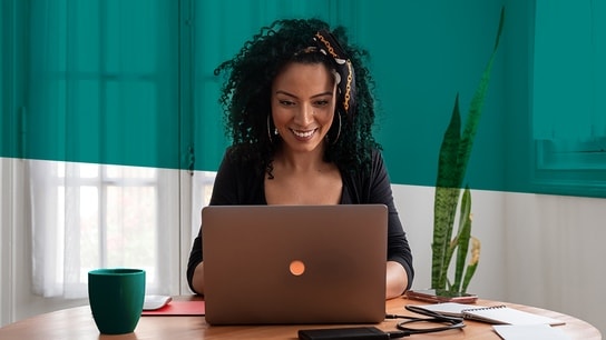 The image shows a woman working with a laptop