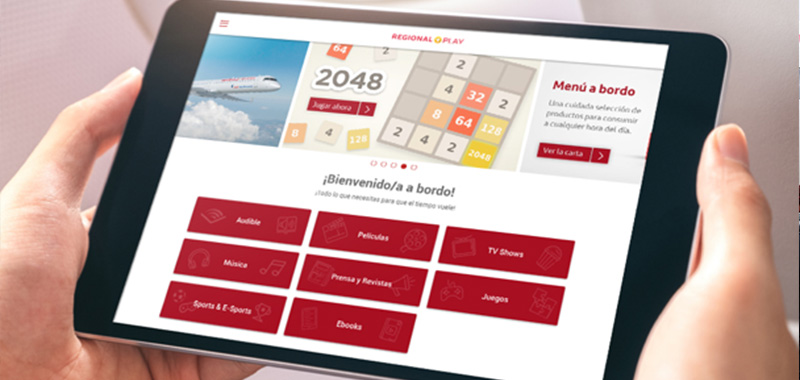 Un pasajero sostiene un dispositivo en el que se ve el sistema de entretenimiento Regional Play, de Iberia Regional Air Nostrum