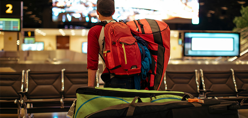 A man carrying oversized baggage at the airport