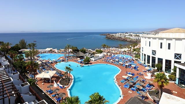Pool at Sandos Papagayo Hotel, facing the beach with sea views.