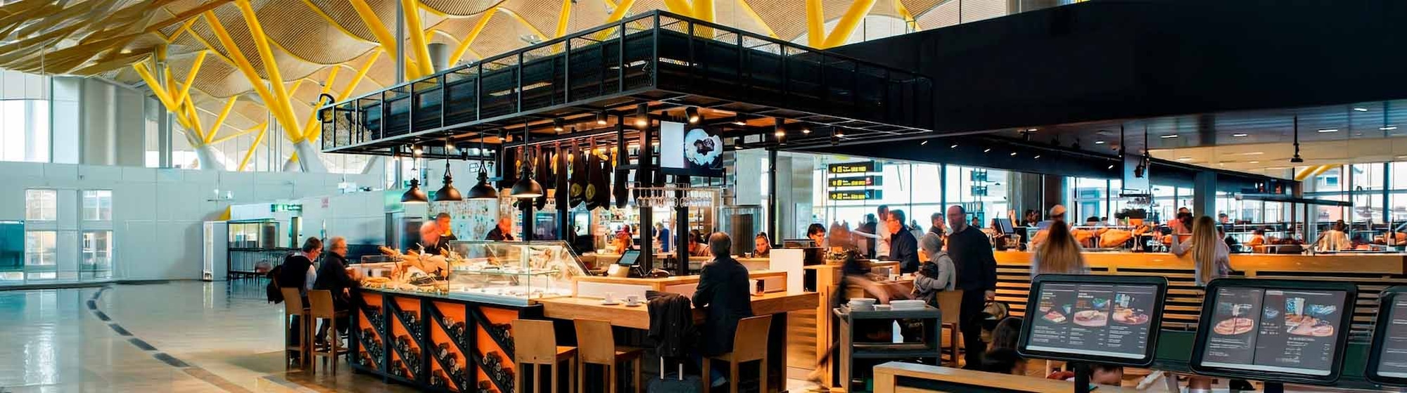 Una pareja de clientes compra en un puesto de comida en un aeropuerto.