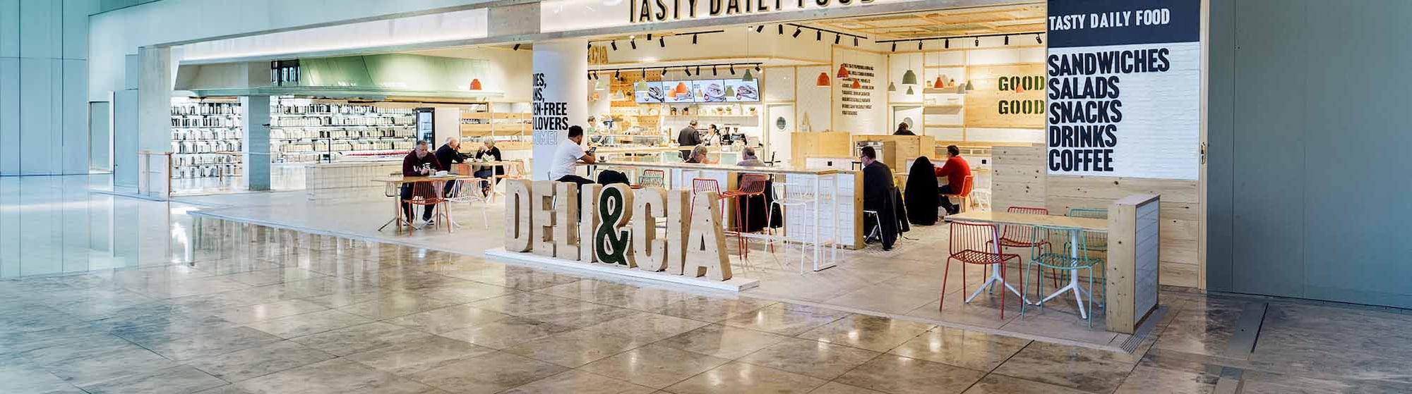 Una pareja de clientes compra en un puesto de comida en un aeropuerto.