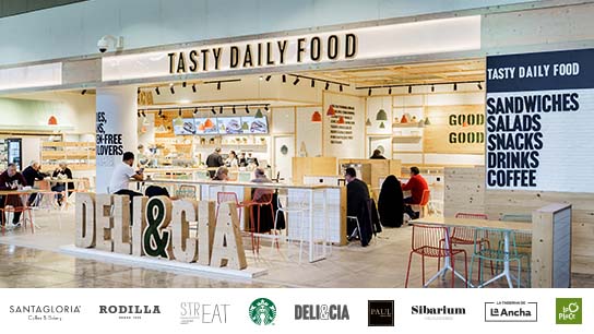Una pareja de clientes compra en un puesto de comida en un aeropuerto.