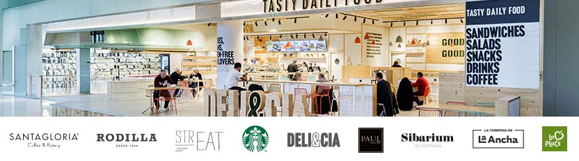 A couple of customers are buying at a food stall in an airport.