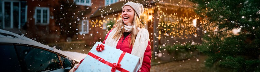 The image shows a curved road with a red car driving on it, surrounded by vegetation and earth.