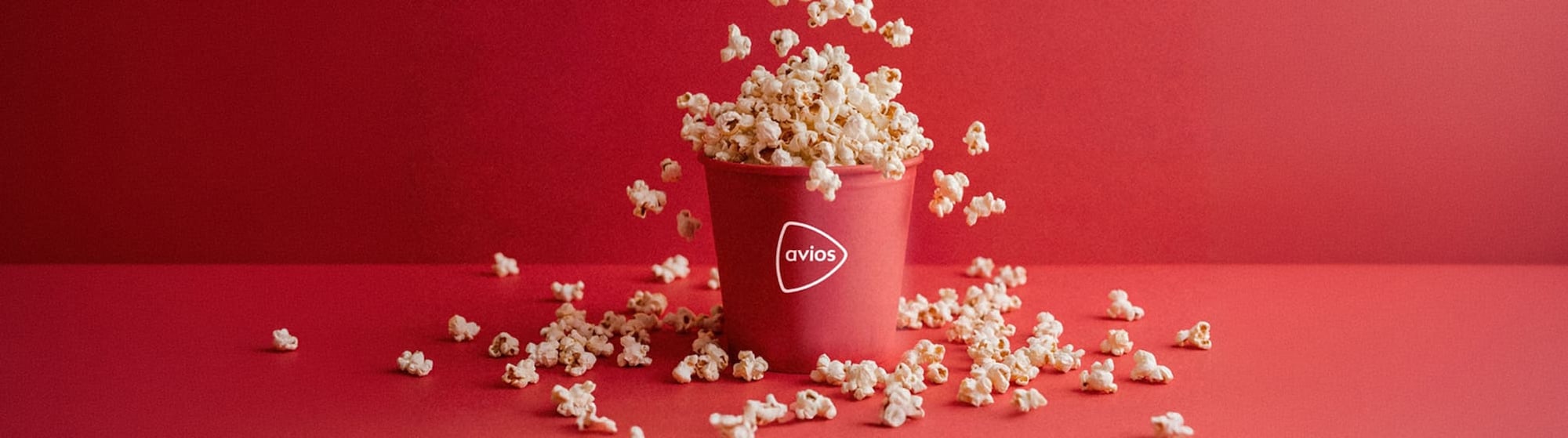 La imagen un cubo de palomitas con el logo de Avios