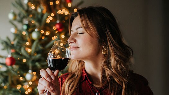 The image shows two wine glasses on a barrel that serves as a table