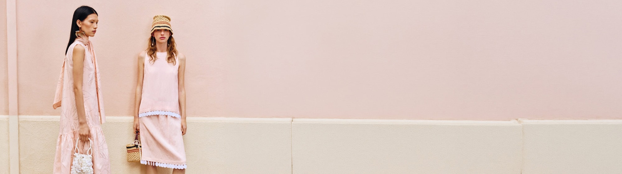 La imágen muestra a dos mujeres con vestidos rosas